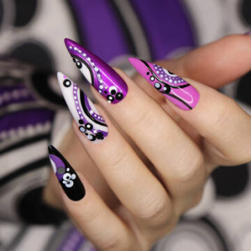 Manicure on long nails with dots and lines.